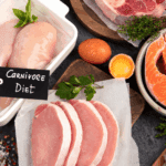 Raw meats, fish, egg, and herbs labeled “Carnivore Diet” displayed on a kitchen counter—representing the variety of nutrient-dense animal foods in a balanced carnivore lifestyle. types of carnivore diet